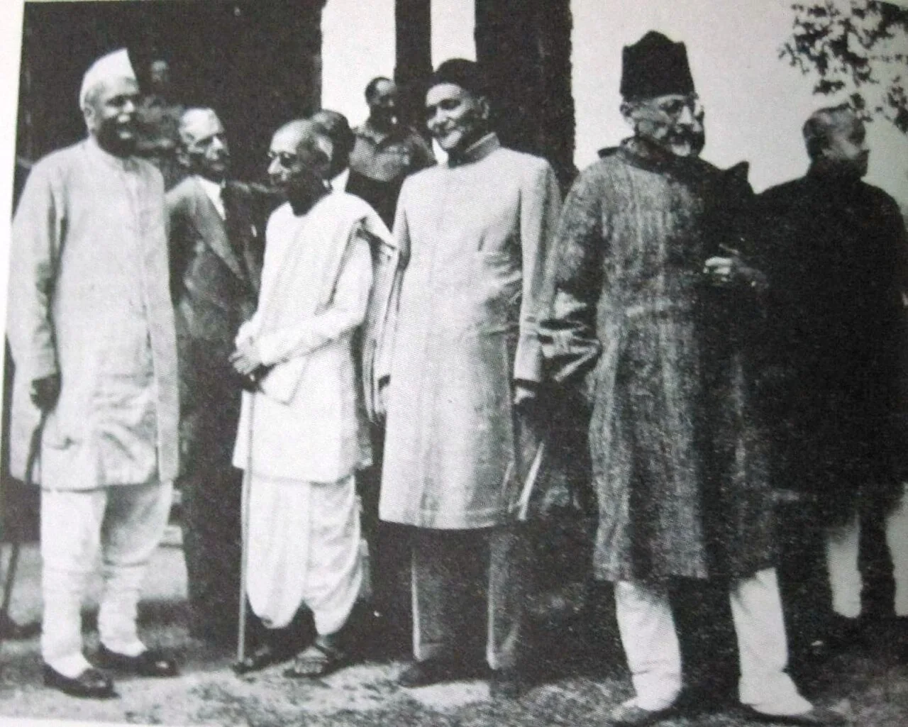 Indian political leaders photographed standing together outdoors at the Simla conference; Maulana Abul Kalam Azad stands at the right in a long coat and cap.